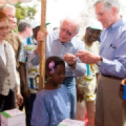 Former U.S. President Jimmy Carter and Carter Center CEO and President John Hardman measure a little girl's height to gauge the accurate medication needed to prevent schistosomiasis, a silent and destructive parasitic infection that leads to poor growth and impaired learning in children. General Yakubu Gowon, Nigeria's former head of state who now advocates for Carter Center-assisted health programs in the country, looks on.