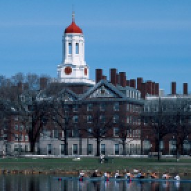 USA, Massachusetts, Boston. Rowers on Charles River with Harvard University Campus behind.